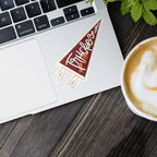Laptop with a pennant-shaped "Truckee, California" sticker on a wooden surface next to a cup of coffee