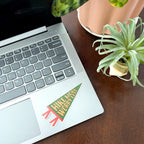 Laptop on a wooden desk with a plant and 'Hike More, Worry Less' sticker.