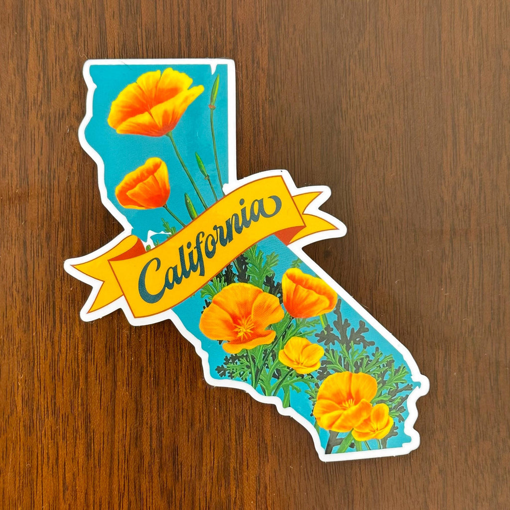 Sticker of California with orange flowers and a banner that says "California" on a wooden surface
