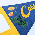 Felt banner with yellow poppy flowers, green leaves, and 'California' text on a blue background