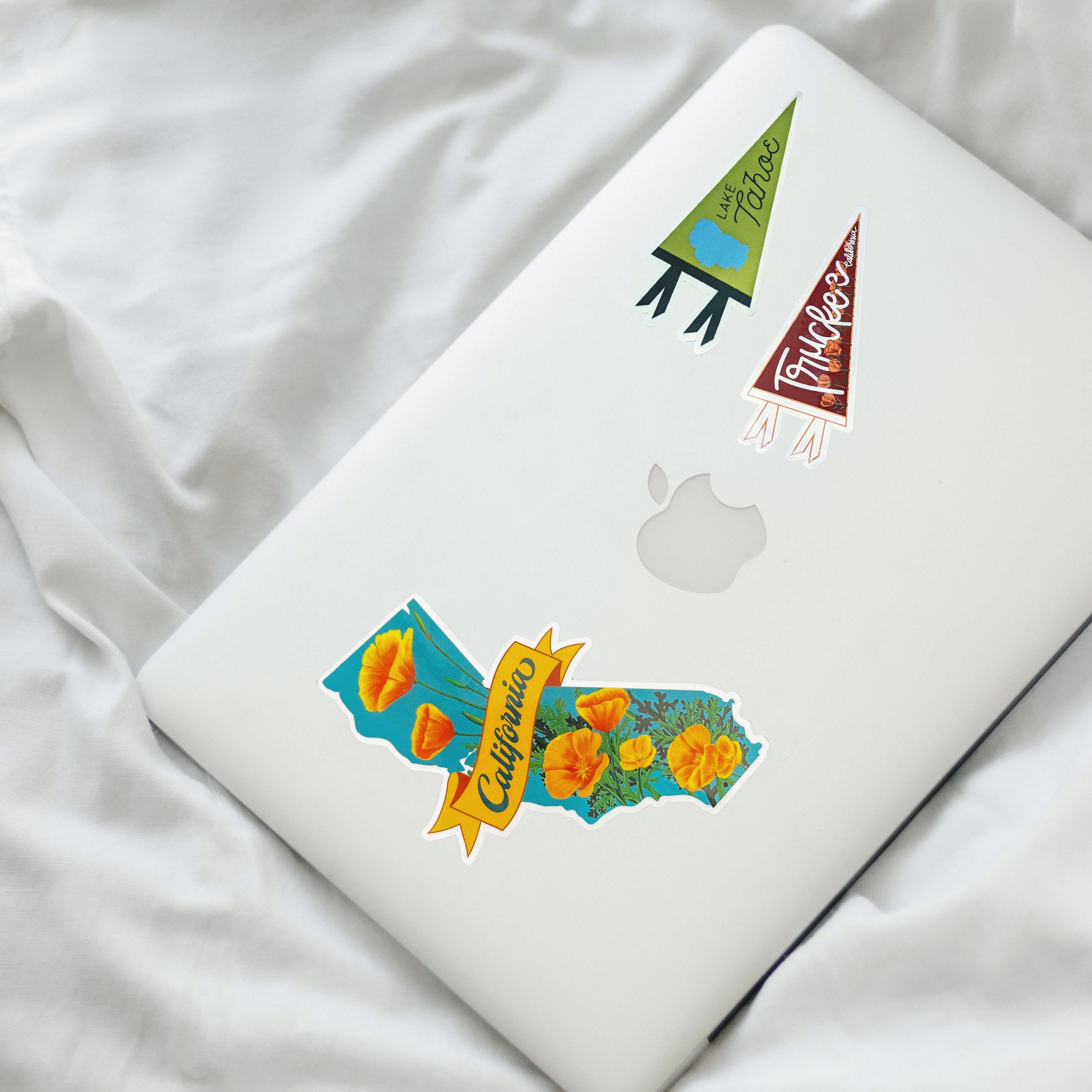 Laptop with decorative stickers on a white fabric background