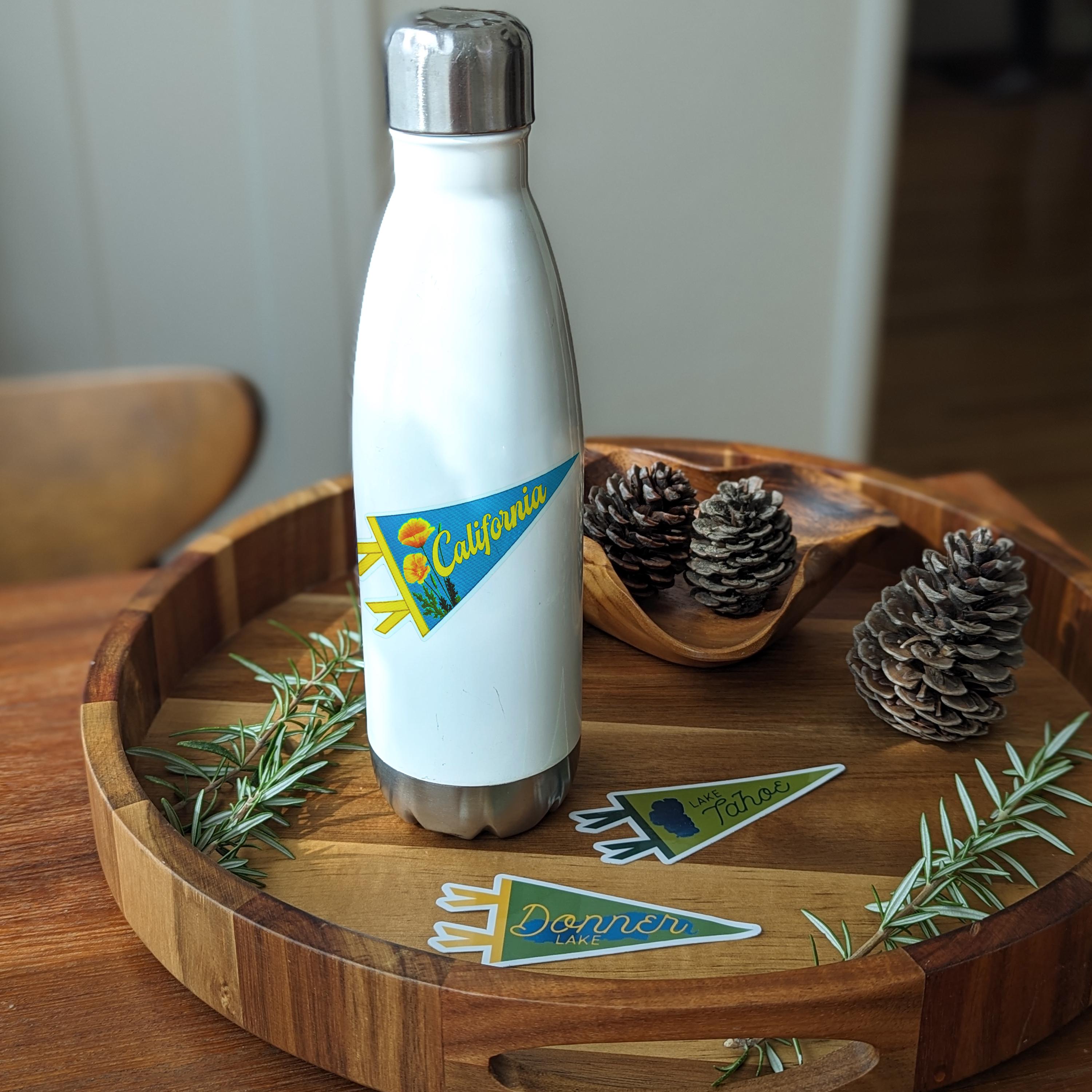 White water bottle with 'California' pennant-shaped blue and orange sticker with flowers 