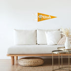 White sofa with wooden legs in a living room setting, featuring a 'Utah' flag on the wall.