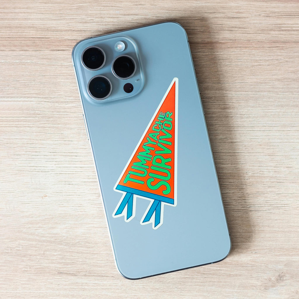 Phone case with 'Tummyache Survivor' pennant-shaped orange, green and blue sticker