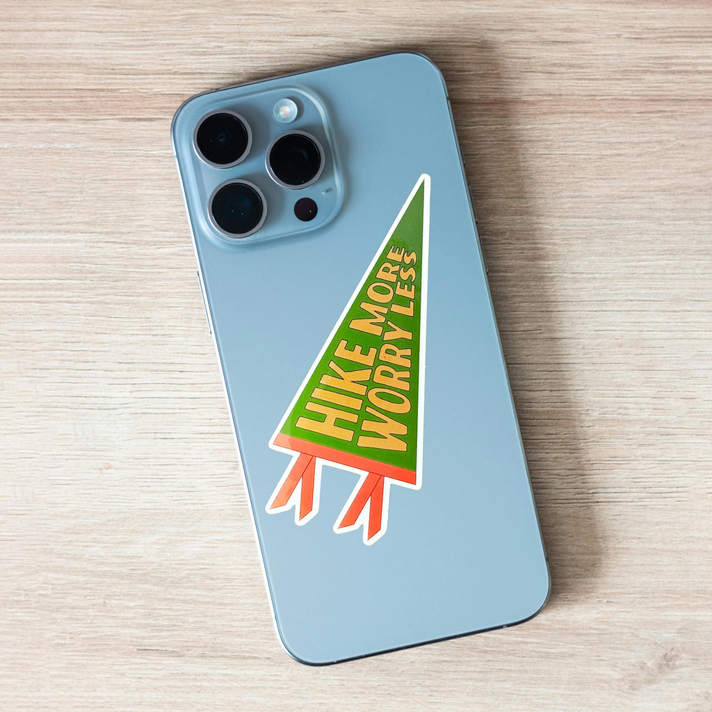 Phone case with a 'Hike More Worry Less'  pennant-shaped sticker on it