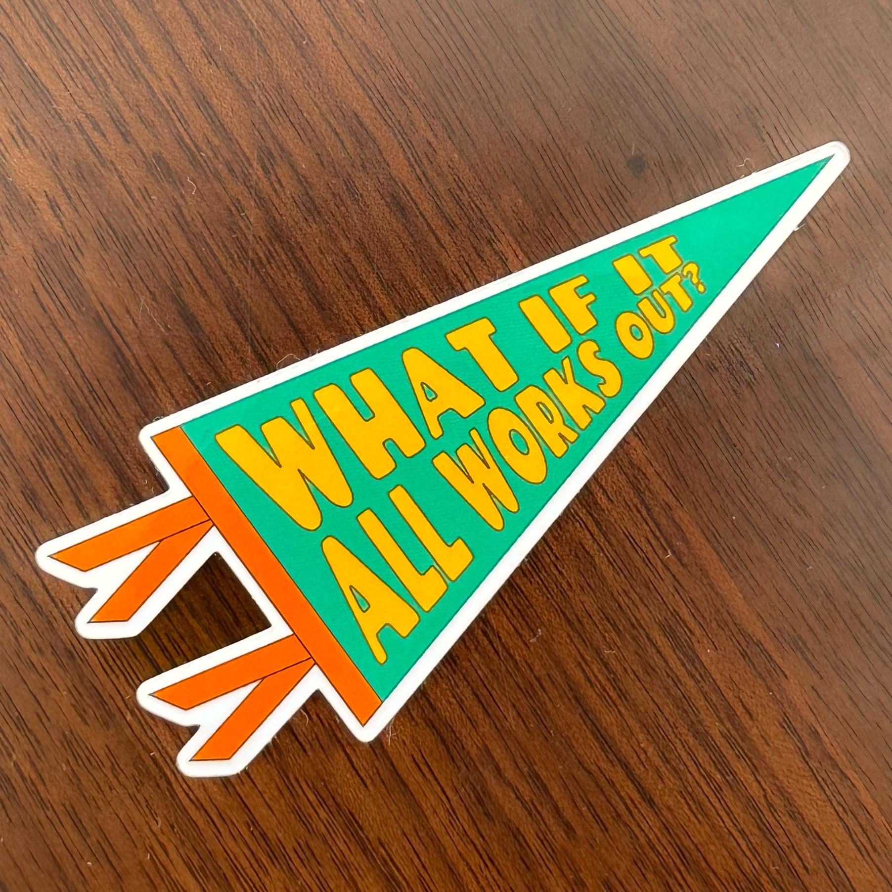 Sticker with 'What if it all works out?' text on a wooden surface