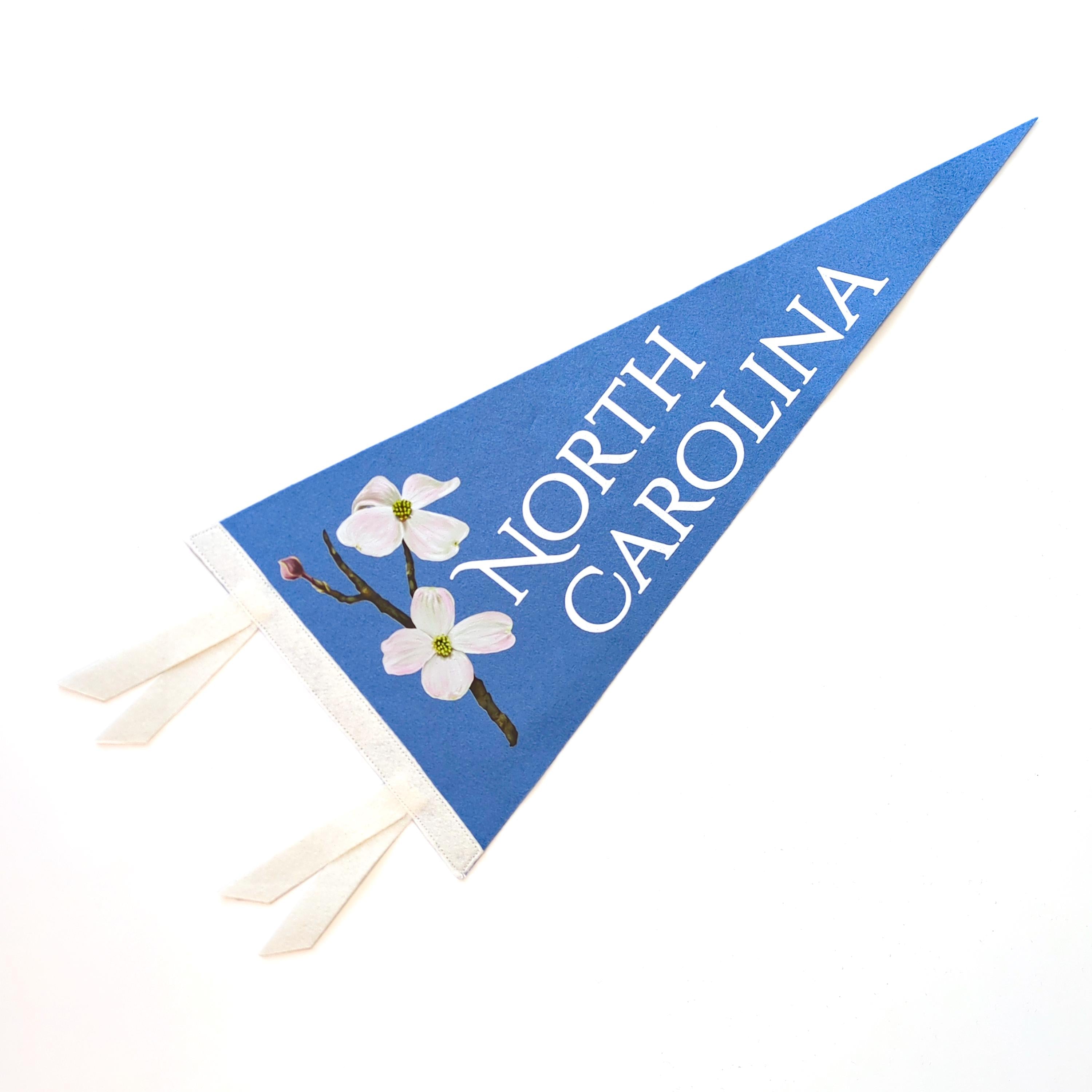 Blue pennant with 'North Carolina' and dogwood flowers on a white background